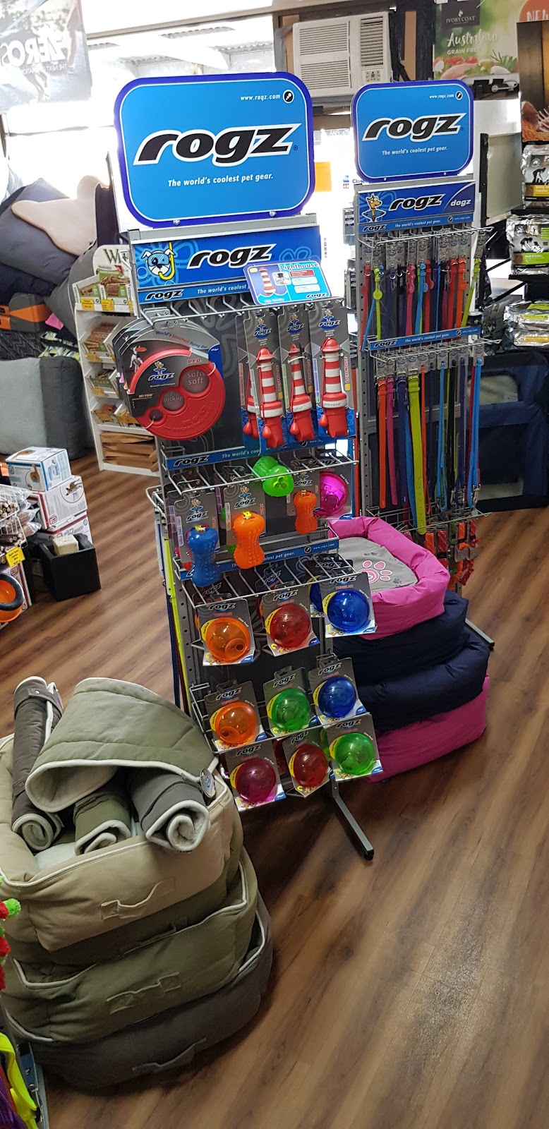 A Rogz display with dog beds stacked beside it